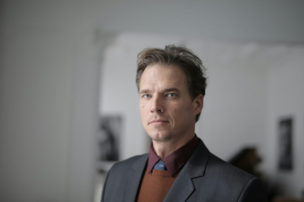 Portrait of a businessman in a formal suit in an indoor setting.